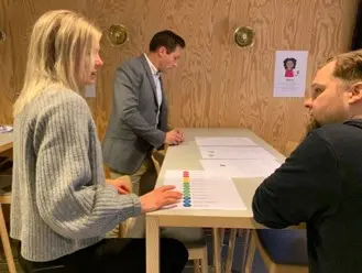 Människor vid bord på ett arbetsmöte.