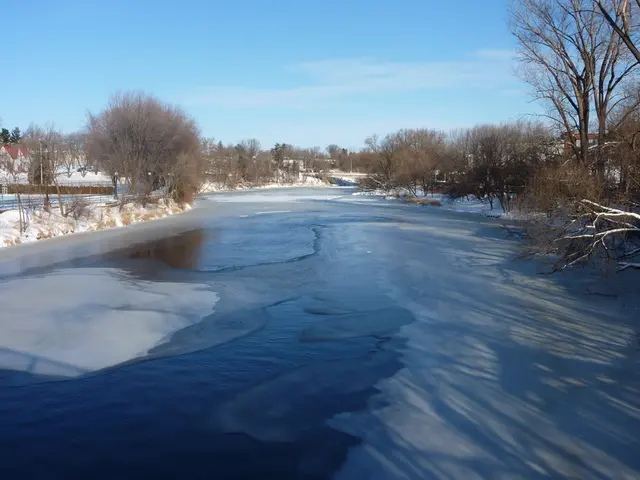 Photo of a river in winter time, partly covered by ice.