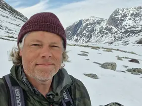 Foto på en man (David) i ett snöigt landskap.